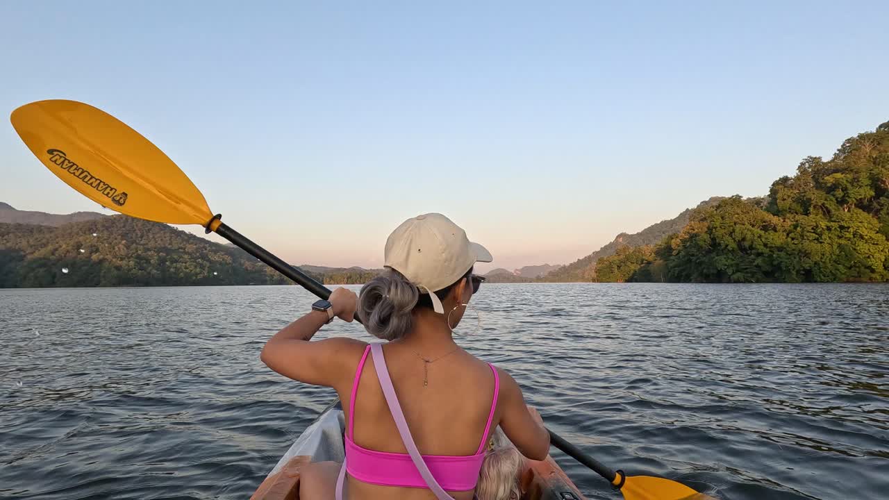 persona remando en kayak en aguas tranquilas al atardecer