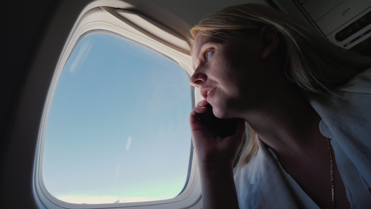 여객기 객실에서 전화로 통화하는 비즈니스 우먼