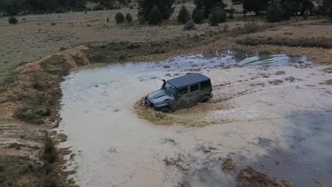 offroad car crossing water puddle drone view