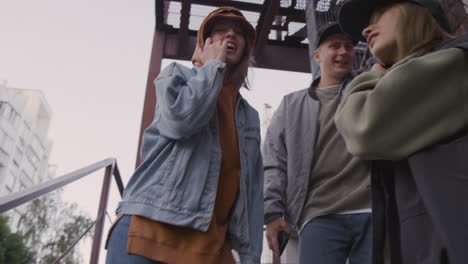 young friends listening to music on the stairs