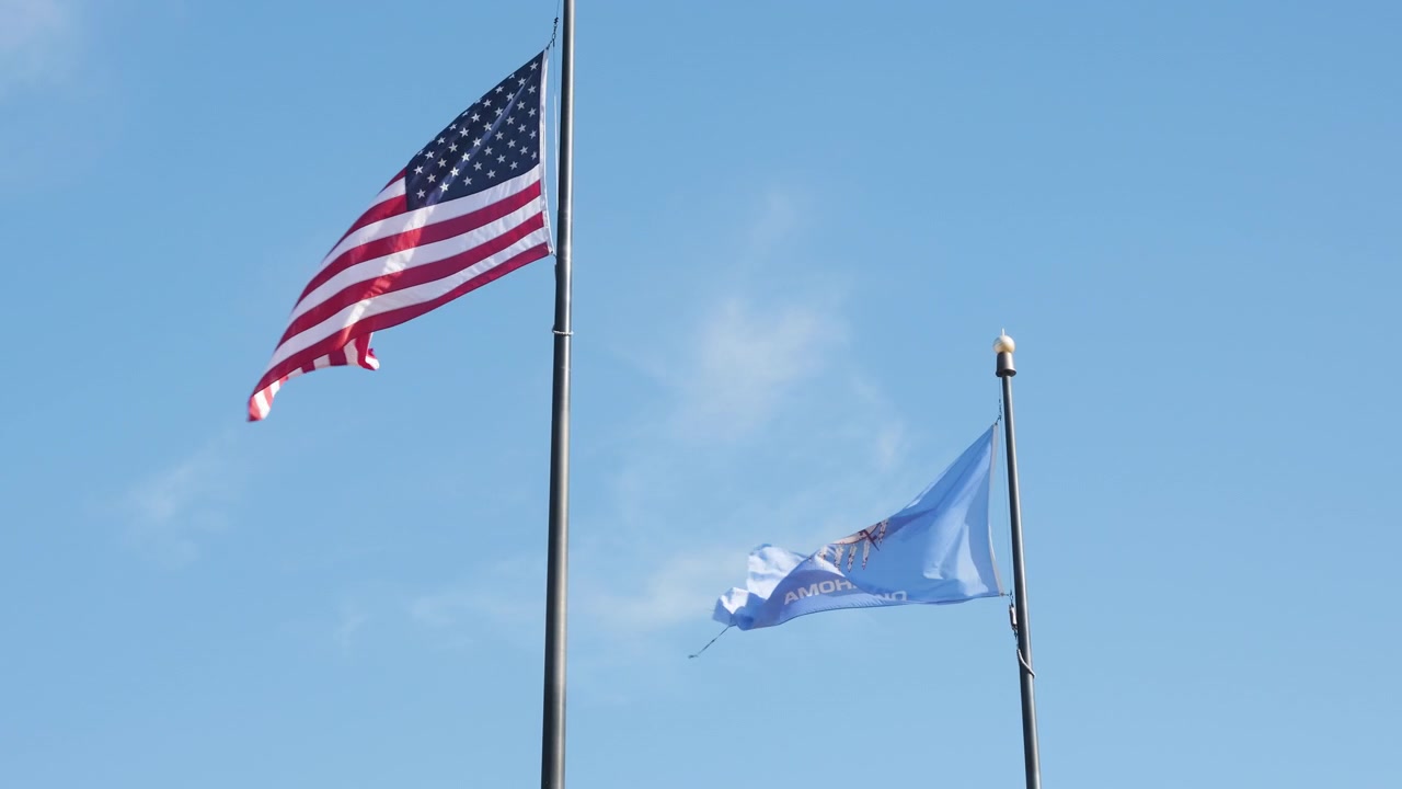 The American and Oklahoma flags flying next to each other, slow motion