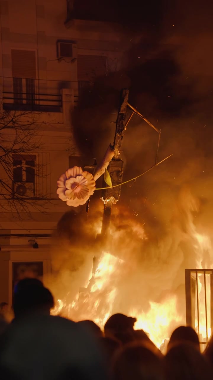Figura floreale su palo sopra una falla in fiamme durante la cremà de Las Fallas