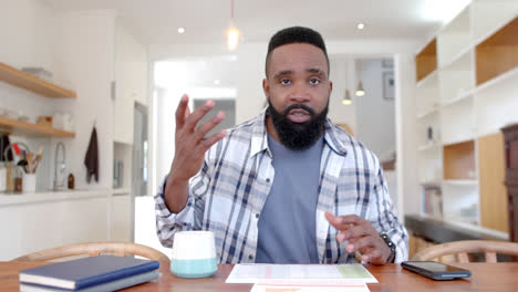 african american man making video call at home, slow motion