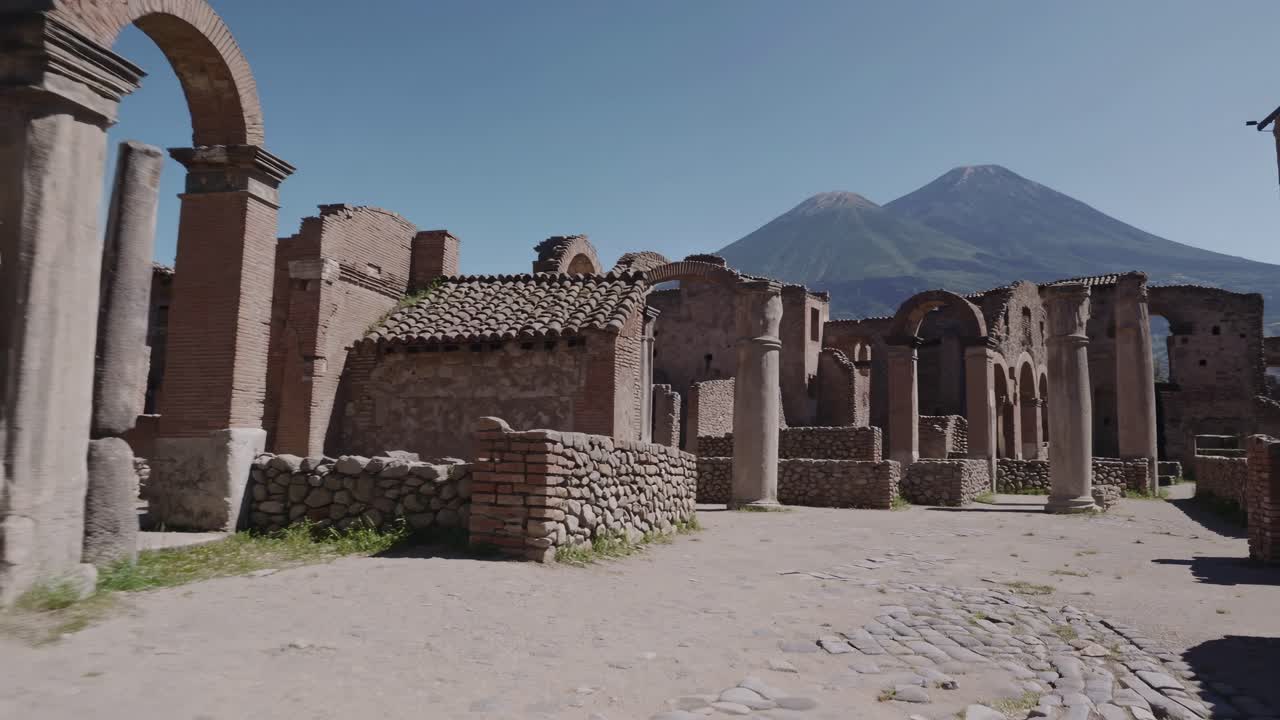 Wide-angle video shot of ancient ruins with stone columns and walls, set against a backdrop