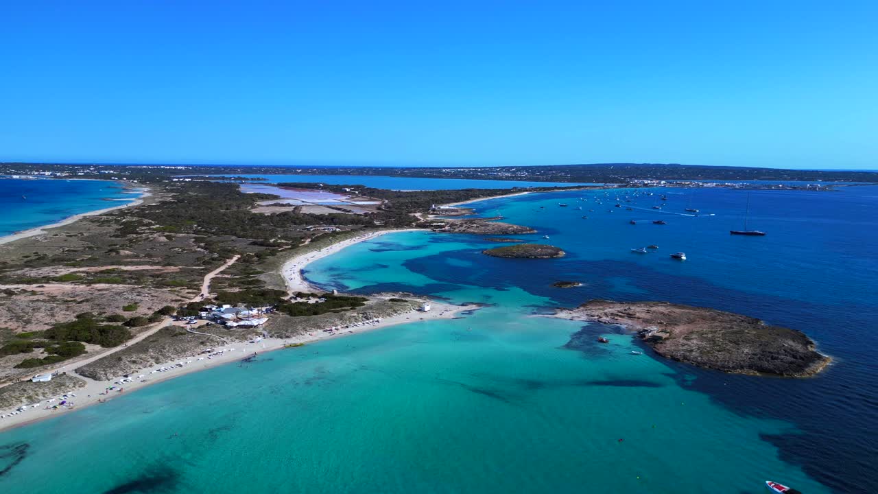 Formentera island landscape Ses Illetes beach bay with shallow blue turquoise sea and boats. Fantastic aerial view overflight flyover fly push forward drone