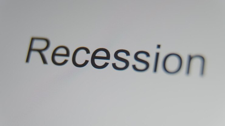 A close up of a digital screen showing a text cursor and "recession" being typed