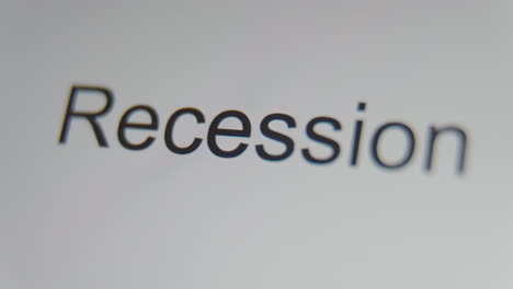 a close up of a digital screen showing a text cursor and "recession" being typed