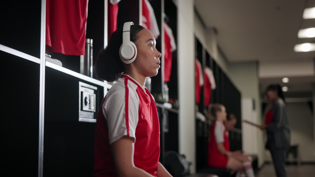 Female athlete in locker room wearing headphones