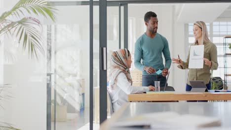 Busy-diverse-business-people-discussing-work-at-table-with-laptop-in-slow-motion