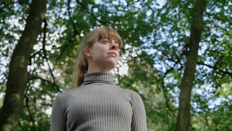 girl admires nature as camera circles her in woods, low angle