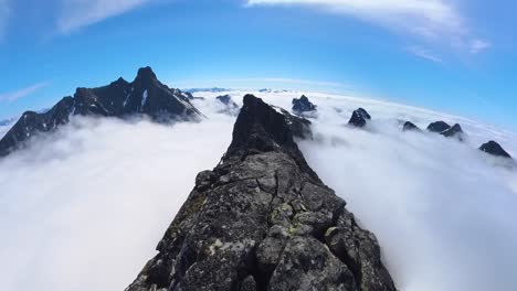pov alpinismo en la escarpada cresta de la montaña por encima de las nubes durante un día soleado en las montañas noruegas