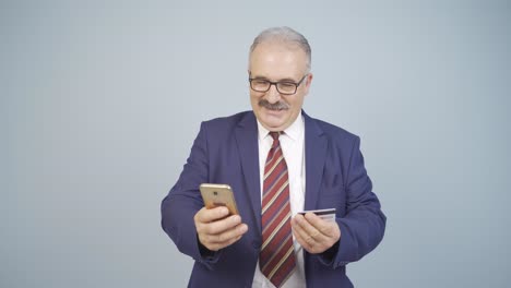 hombre de negocios comprando por teléfono con una tarjeta de crédito.