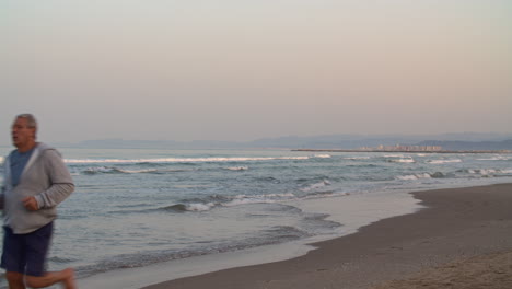 Hombre-Jubilado-Corriendo-En-La-Playa-Al-Atardecer