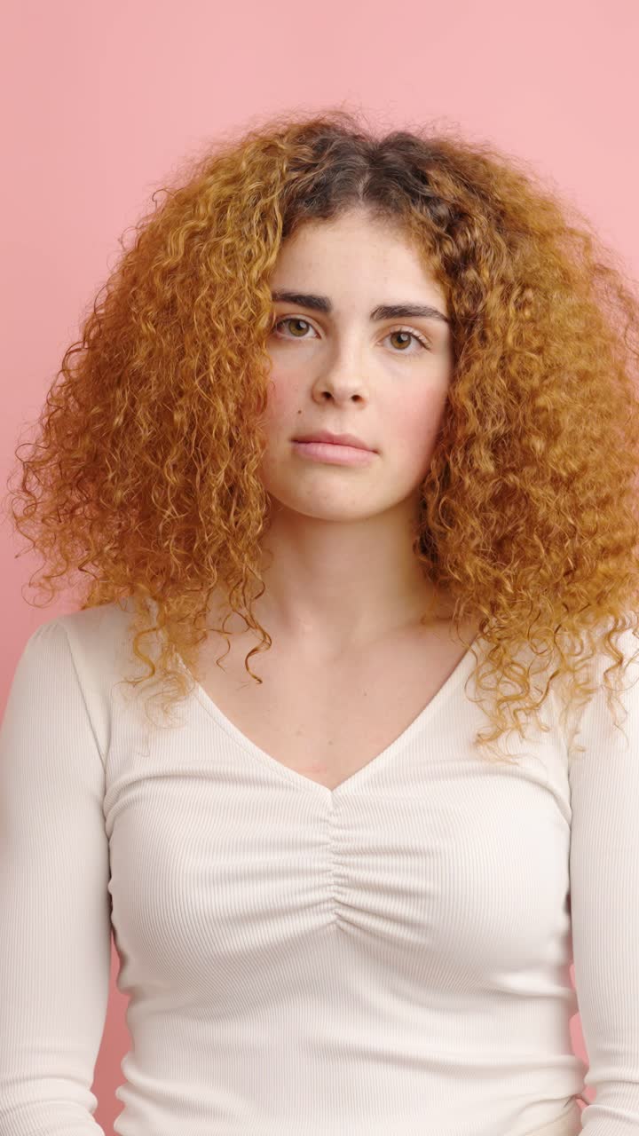 Young woman showing different facial expressions on pink background