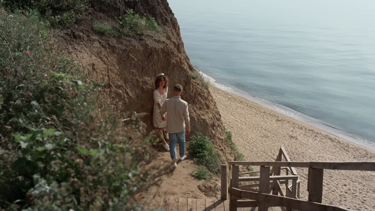 un día soleado en la playa. un chico alegre besando a una chica encantadora en la orilla del mar.