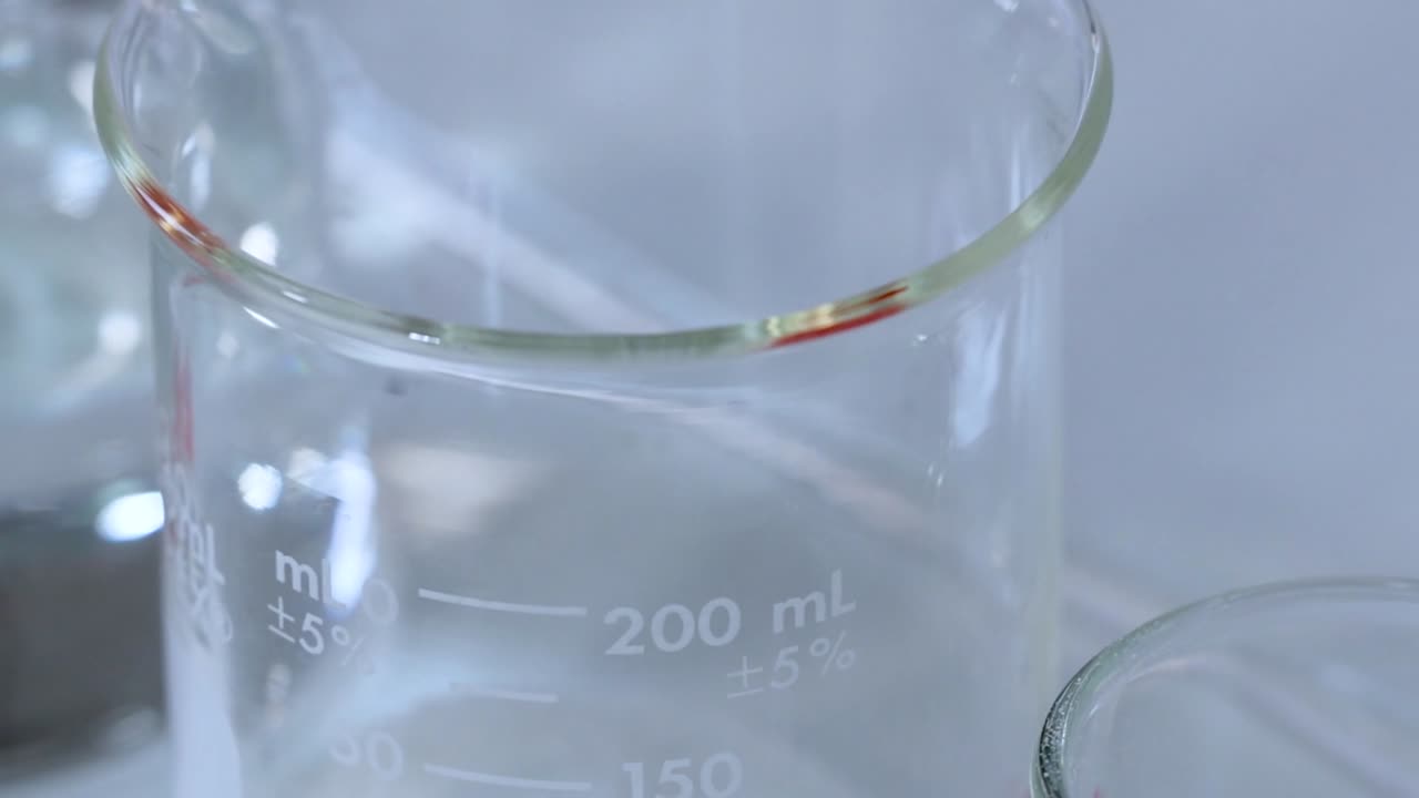 A detailed view of empty glass beakers in a laboratory setting, highlighting their measurement markings.