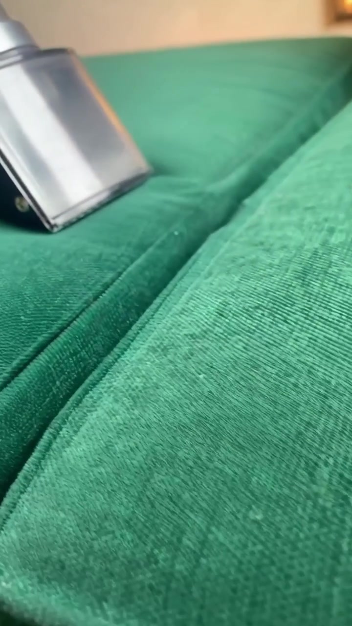 Handheld Vacuum Cleaner Cleaning Green Velvet Sofa
