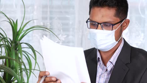 businessman reading documents while wearing a mask