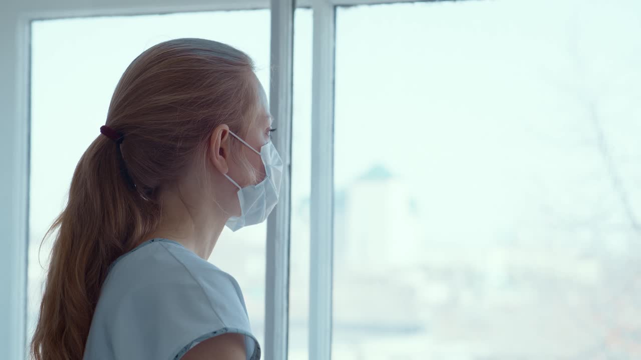 Woman Wearing a Mask Looking Through a Window