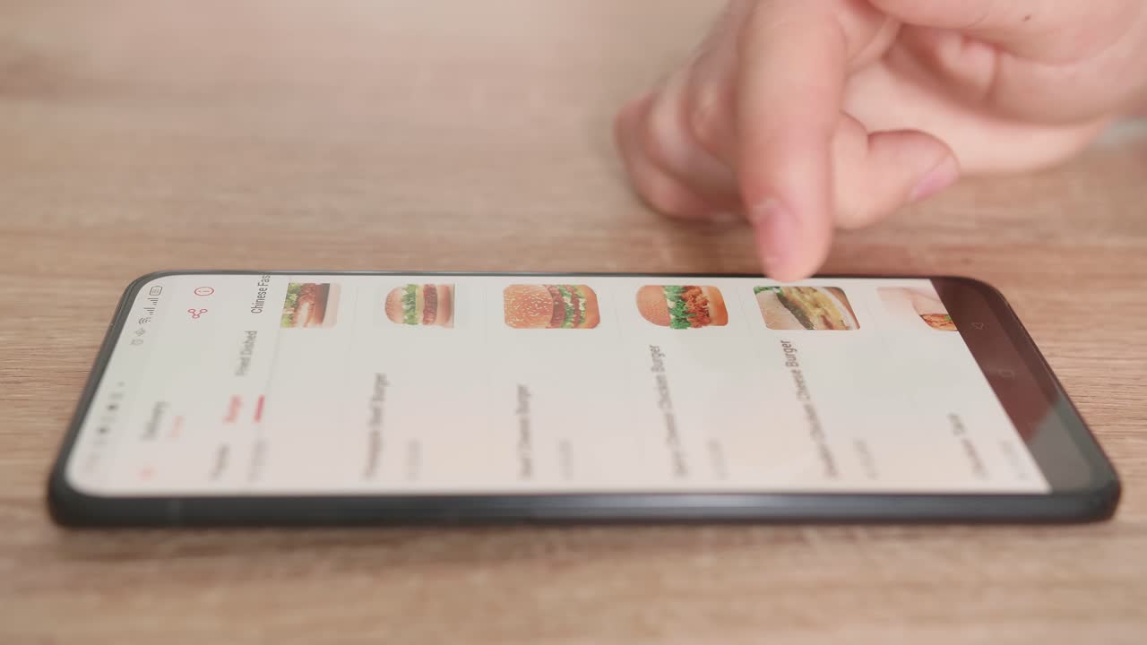 Close Up Of Hand Male Selects Food In Food Online Delivery Apps Directly On Smartphone