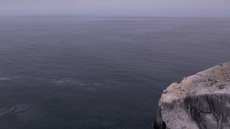 aerial shot revealing rocks off the coast of big sur, california