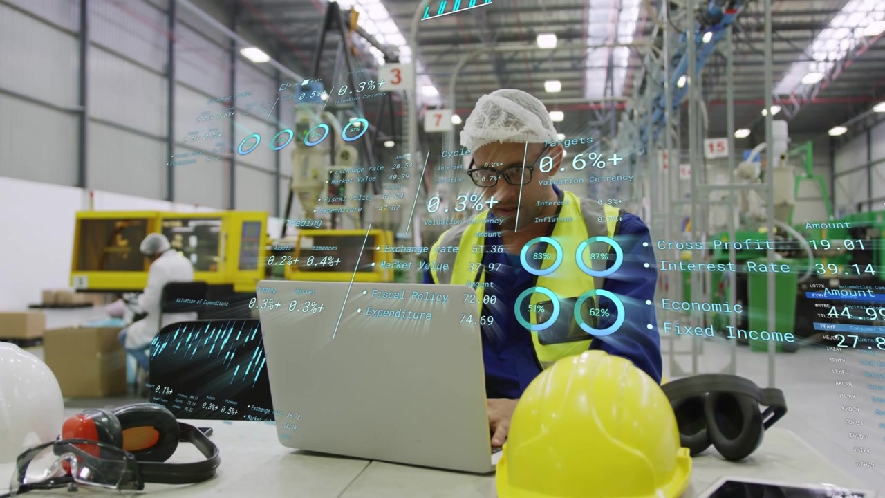Male worker typing at laptop on plant, causing charts to appear for QC and sipping drink