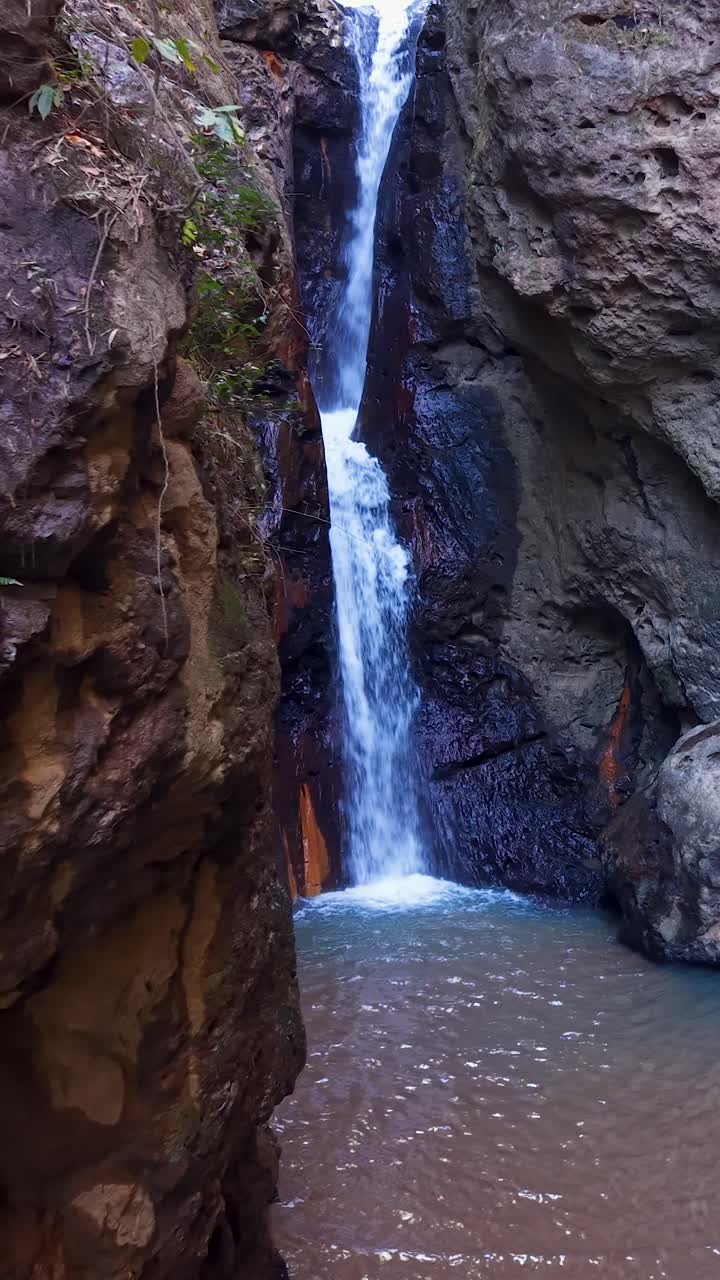 Stunning video captures the dramatic flow of Pam Bok waterfall in Northern Thailand's lush setting. Aerial footage beautifully showcases the rocky cliffside