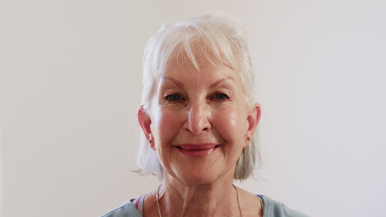 Smiling senior woman enjoying peaceful moment at home, feeling content, copy space