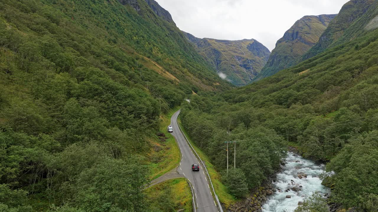 Ripresa con drone di un'auto che percorre una strada panoramica nella valle in Norvegia