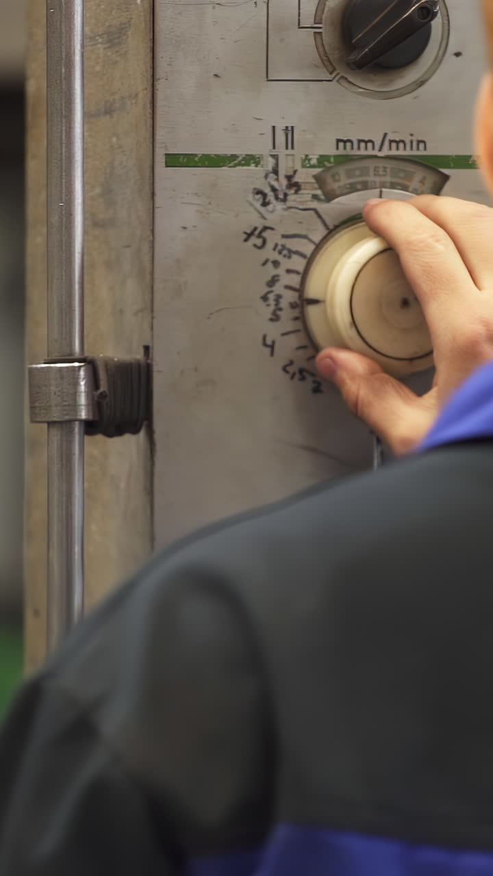 Worker Adjusting Controls on Industrial Machine