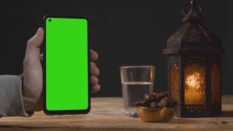 wide shot of lantern dates and water with green screen phone