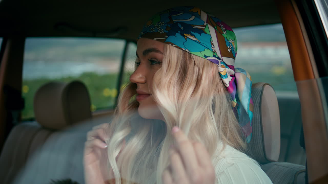 Arabada oturan bandana takan hipster kız, yakın çekim. Retro otomobilde poz veren kadın