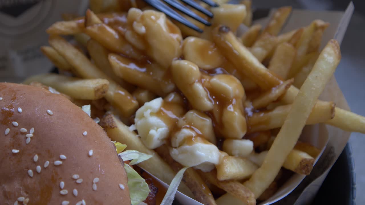 Close-up view of a delicious poutine dish with french fries, cheese curds and gravy.