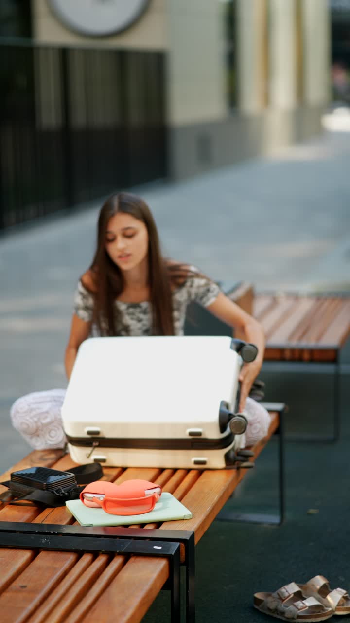 mujer empacando equipaje en un banco del parque