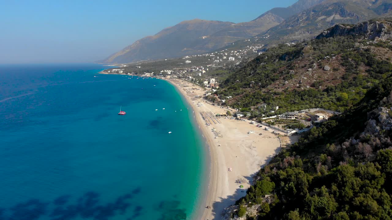 Beautiful beach of Dhermi in Albania surrounded by blue turquoise sea water and green hills