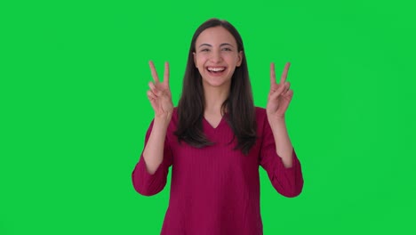 Happy-Indian-girl-showing-victory-sign-Green-screen