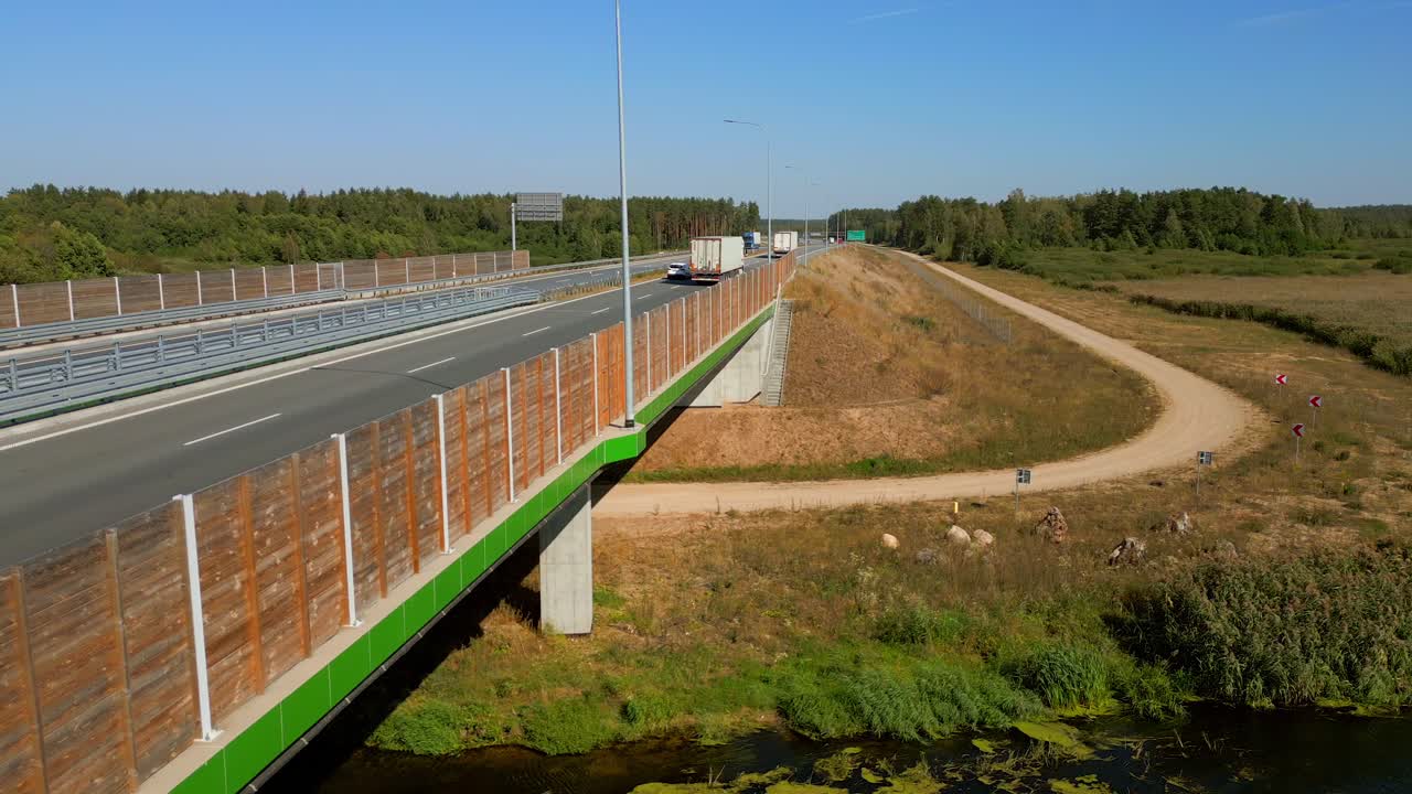 camiones de servicio de carga en carreteras expresas a través de bosques naturales, disparo de panorámica de la cámara