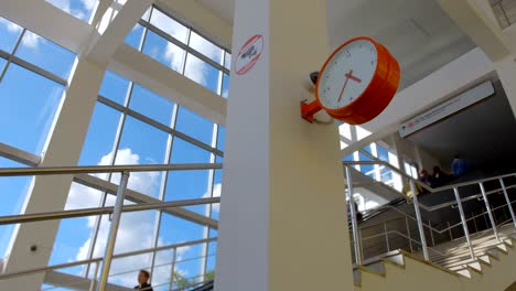 hermoso reloj rojo de moda y cámara de cctv al lado de las escaleras