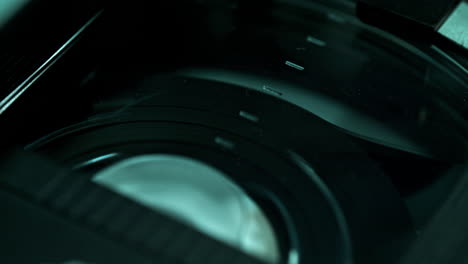 rewinding the video tape inside of the dusty plastic cassette shell - macro, cold interrogation room