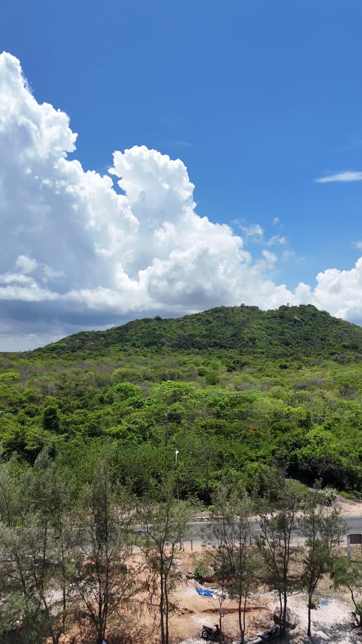 Panoramica aerea inclinata della spiaggia rocciosa e della foresta a Ho Tram.