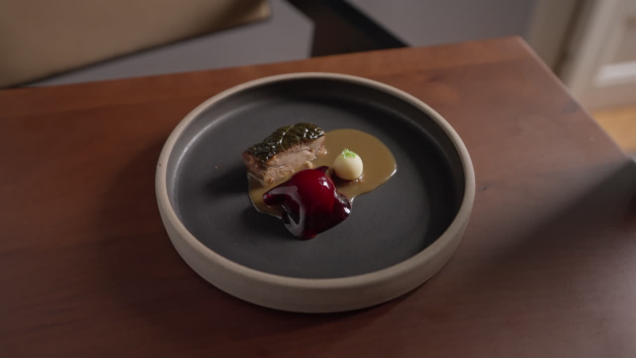 Elegant plate of food with pork, sauce, and artistic presentation