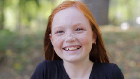 Natural Appearance of a Girl with Beautiful Freckles on her Face Teenage Girl with Blue Eyes and Freckles on her Face Looks at the Camera Close up