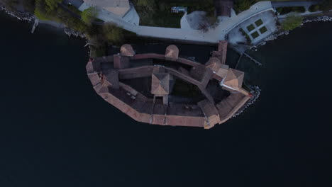 top down rise aerial shot above an old winery along the waterfront of lake geneva near montreaux, switzerland