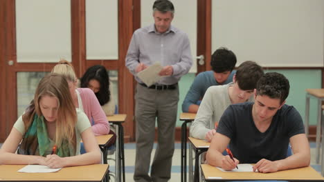 Schüler-Machen-Einen-Test,-Während-Der-Lehrer-Herumläuft