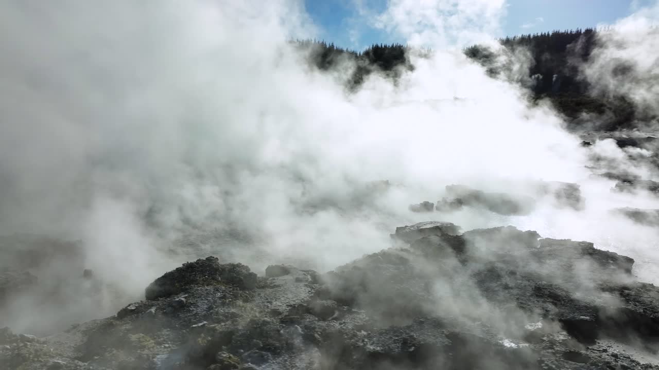 Extreme steamy mud pools, Drone slowly flying over geothermal landscape. Trees, steam, bubbling mud and steam. Alien Landscape. Sci-fi. Global Warming