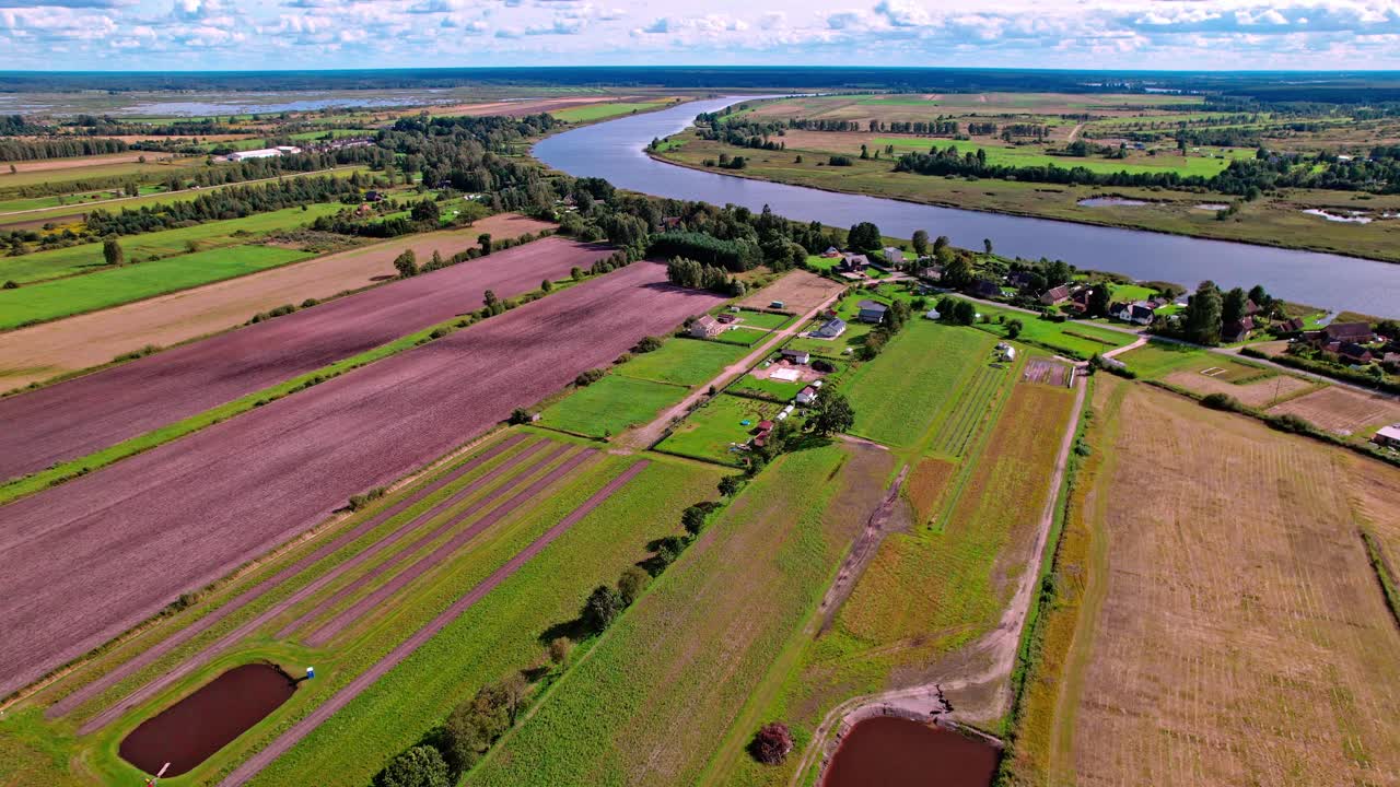 Aerial view of picturesque farmland in Latvia with winding river