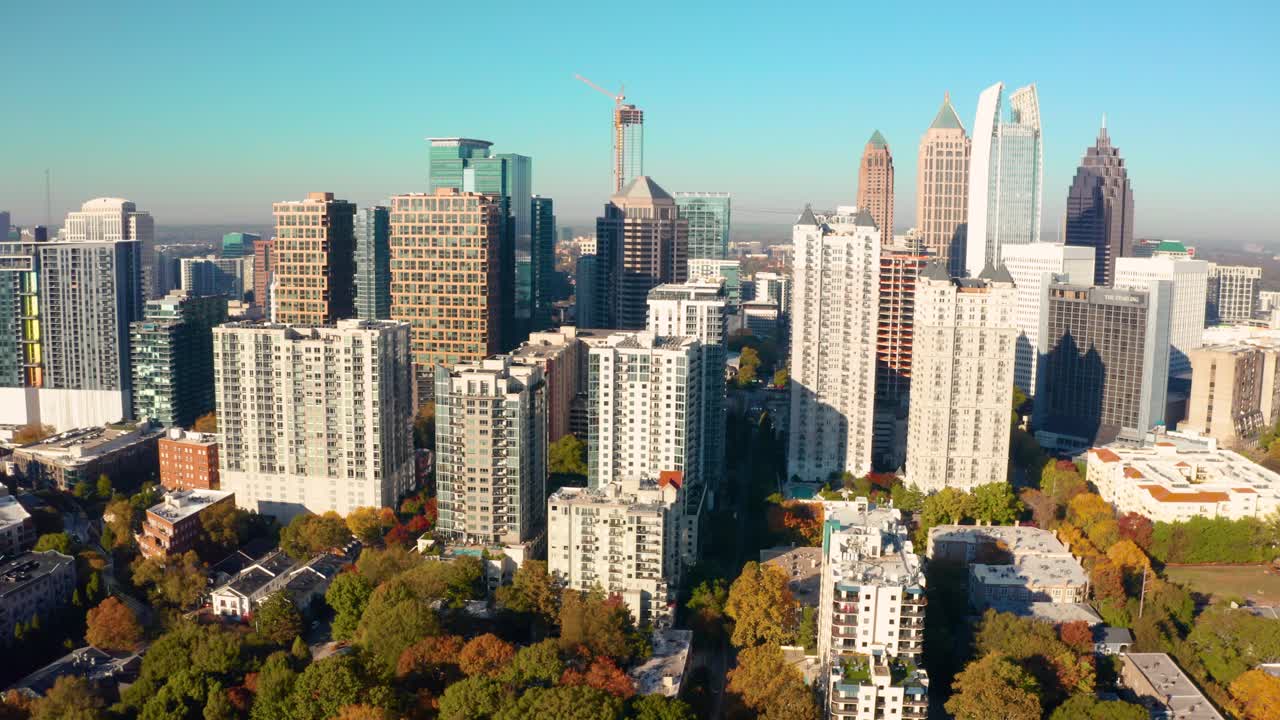Flying over Piedmont Park towards downtown Atlanta Georgia with skyscrapers and Fall colors