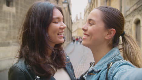 Toma-POV-De-Una-Pareja-De-Mujeres-Del-Mismo-Sexo-Posan-Para-Un-Selfie-Mientras-Visitan-Oxford,-Reino-Unido-Juntas