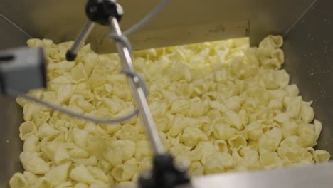 la línea de producción de la fábrica mueve las patatas fritas doradas después de freír. línea de fabricación de la fábrica de pasta
