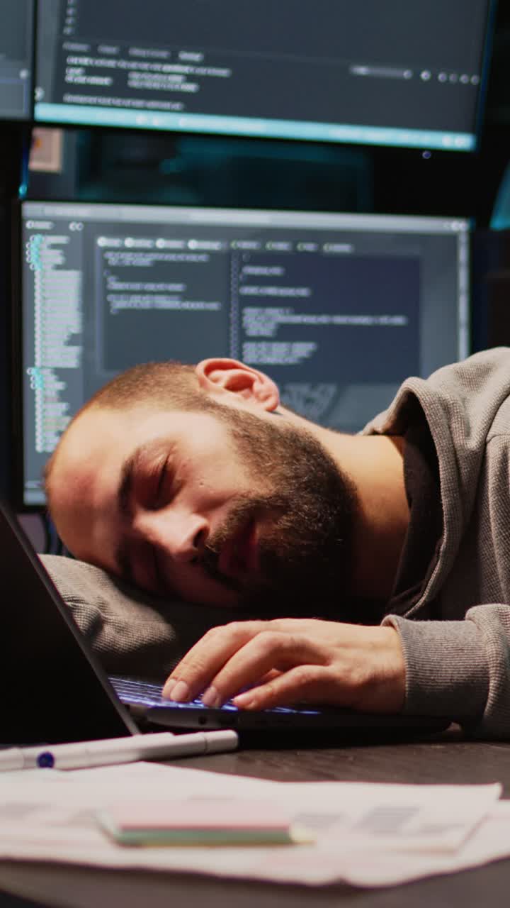 Vertical video: Software engineer yawning and falling asleep on desk